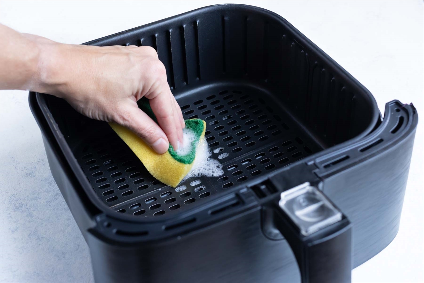 Làm sạch khay chiên với xà phòng, nước nóng và miếng bọt biển mềm